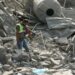 An emergency worker looks through rubble in the aftermath of an airstrike on Ansar in Lebanon