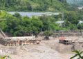 Mud and sand are piled up against a hydropower plant affected by a flash flood in northern Nepal