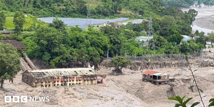 Mud and sand are piled up against a hydropower plant affected by a flash flood in northern Nepal