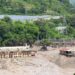 Mud and sand are piled up against a hydropower plant affected by a flash flood in northern Nepal