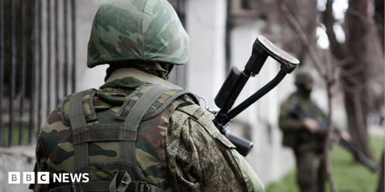 An unidentifiable Russian soldier stands with his back to the camera