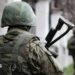 An unidentifiable Russian soldier stands with his back to the camera