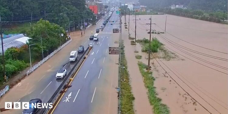 Cars pass through a severely flooded highway in Geoje, Gyeongsang, South Korea