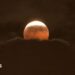 The Moon has a red tinge as it rises above clouds during the partial eclipse over Anaheim, California