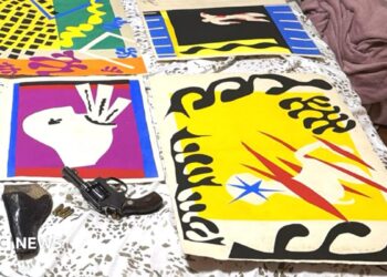 The Matisse illustrations - bold cut out collages in primary colours and black - are pictured laid out on a bed, alongside a handgun