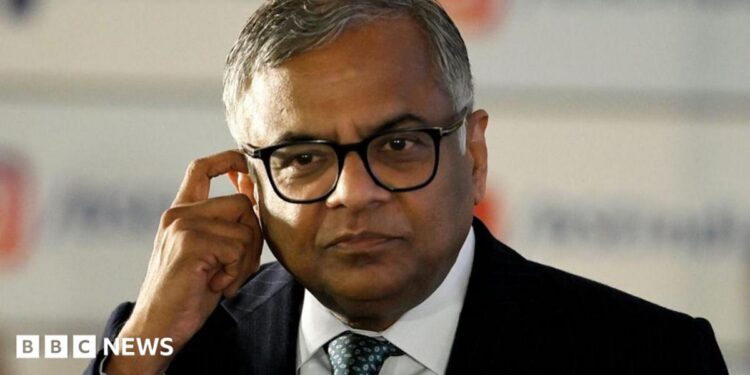 N Chandrasekaran, wearing a dark suit, white shirt and thick-rimmed glasses, touches his ear in this photo taken at the Bombay Stock Exchange in Mumbai, India, on November 12, 2025.