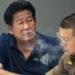 Chalong blows smoke through his nose