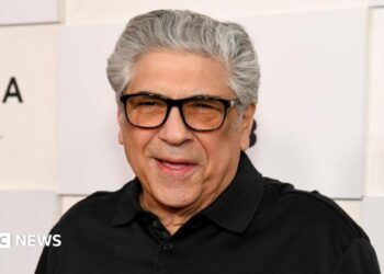 Vincent Pastore wears a black polo shirt and black-rimmed glasses.