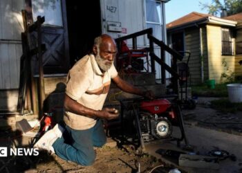 Anthony Lewis repairs a generator at his home while coping without electricity, as thousands of residents remain without power more than a week after severe storms struck Gary, Indiana.