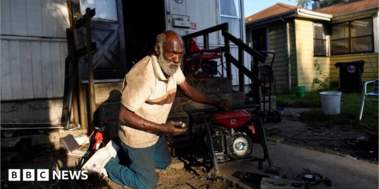 Anthony Lewis repairs a generator at his home while coping without electricity, as thousands of residents remain without power more than a week after severe storms struck Gary, Indiana.