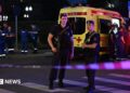 Armed Moscow police stand guard in front of an ambulance near the scene of an explosion near the centre of the city.