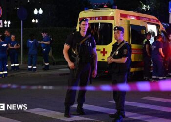 Armed Moscow police stand guard in front of an ambulance near the scene of an explosion near the centre of the city.