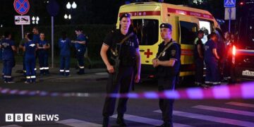 Armed Moscow police stand guard in front of an ambulance near the scene of an explosion near the centre of the city.