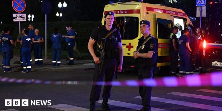Armed Moscow police stand guard in front of an ambulance near the scene of an explosion near the centre of the city.