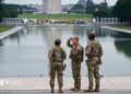 Three members of the National Guard stand in front of the Reflecting Pool