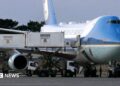 Step-by-step graphic showing how President Trump is reported to have switched planes at Ankara airport in July. Panel one shows Trump boarding the old Air Force One plane to leave Turkey on 8 July. Panel two shows Air Force One on the tarmac, with a catering truck raised to aircraft-door level on the far side and media boarding at the back of the plane. Panel three shows the catering truck driving from Air Force One to a nearby C‑32A military aircraft. Panel four shows Trump exiting Air Force One after reportedly reboarding the aircraft after it landed in the UK. Green circles and labels highlight the catering truck, media boarding point and C‑32A steps. Source: Washington Post, White House pool footage via Reuters.