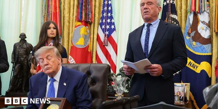 Donald Trump speaks from a lectern during a news conference at the White House. He is accompanied by Robert F Kennedy Jr.