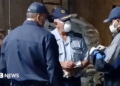 Three officers in face masks and uniform in discussion during a raid on a meth lab found at a farm in Limpopo province