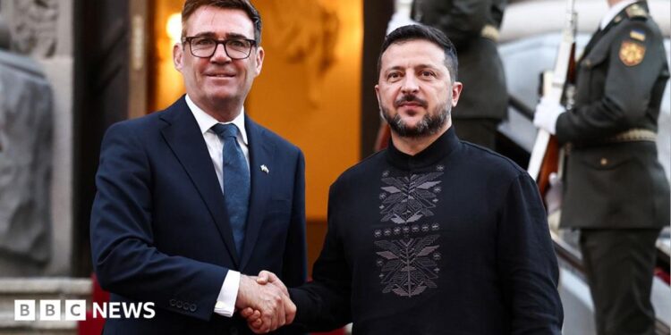 Burnham and Zelensky pose looking at the camera while shaking hands with soldiers behind them, on the steps of Horodetskyi House in Kyiv on Monday.