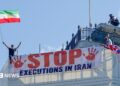 Protesters hold a banner saying "stop executions in Iran" and wave an Iranian flag during a demonstration on the roof of the Trocadero, overlooking Piccadilly Circus, central London (30 July 2026)