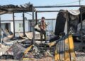 A member of Kurdistan Freedom Party stands next to damaged containers at their military base in Irbil, Iraq, after Iranian drone attack in March
