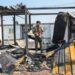 A member of Kurdistan Freedom Party stands next to damaged containers at their military base in Irbil, Iraq, after Iranian drone attack in March