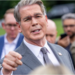 US Treasury Secretary Scott Bessent addresses members of the media on the lawn outside the White House. He's wearing a light grey suit, white shirt and silver tie