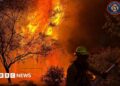 A member of the Spokane Valley Fire Department battles a fire northeast of Spokane, Washington