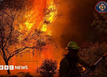 A member of the Spokane Valley Fire Department battles a fire northeast of Spokane, Washington