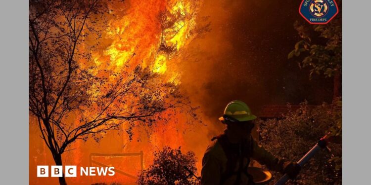 A member of the Spokane Valley Fire Department battles a fire northeast of Spokane, Washington