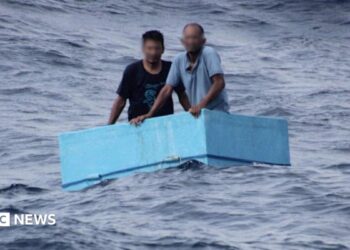 Two men inside a cooling box in the middle of the sea
