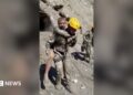 Two rescuers carry people on their backs