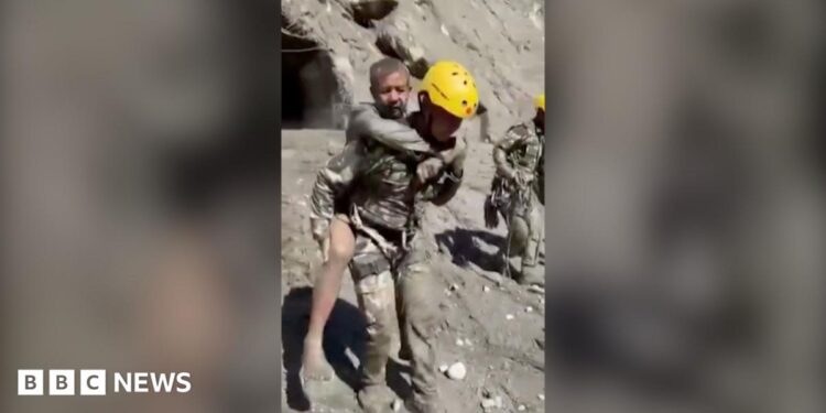 Two rescuers carry people on their backs