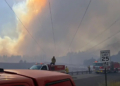 Firefighters respond beneath a massive smoke plume during the Spokane-area wildfires