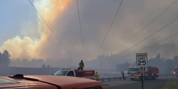 Firefighters respond beneath a massive smoke plume during the Spokane-area wildfires