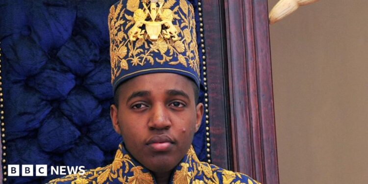 King Oyo pictured at 18 during his coronation wearing a gold embroidered jacket and hat.