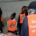 An election official displays a ballot paper as observers look on during the counting of votes after the polls closed at a polling station in Lusaka, Zambia