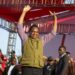 Zambia's President Hakainde Hichilema in green half-coat and black trousers lifts his hands to greet United Party for National Development supporters
