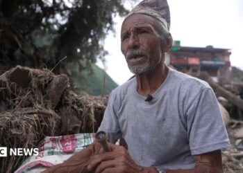 Man sitting in the wreckage of the flood.