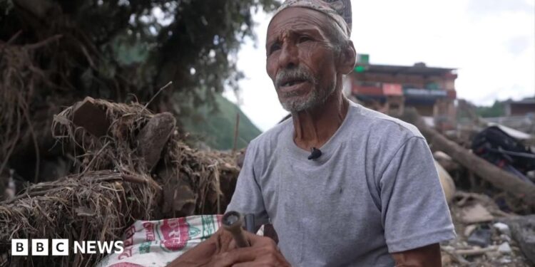Man sitting in the wreckage of the flood.