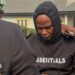 Adeniyi Mobolaji Kayode is in a black hoody with his head bowed as someone has their arm round him as he is led from court in a picture taken in January 20 this year
