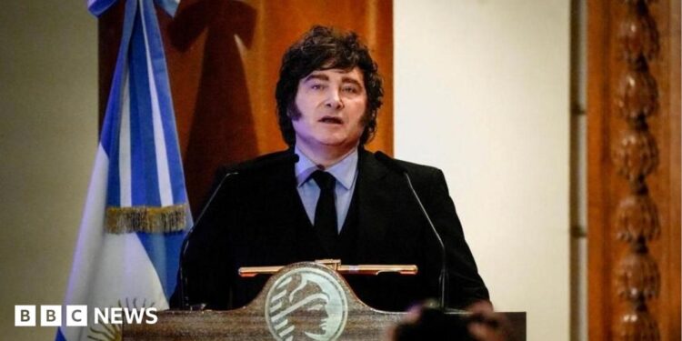 Argentine President speaks during a ceremony commemorating the 172nd anniversary of the Buenos Aires Stock Exchange in Buenos Aires, Argentina, July 16, 2026. He is wearing a dark suit with a black tie and a light blue shirt. He stands at a lectern and to his left there is an Argentine flag.