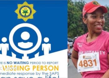 A poster from the South African police which reads: There is no waiting period to report a missing person, next to a photo of Elizabeth Moselakgomo. She is wearing a pink running top with a number pinned to it, along with a pink cap. She is smiling.