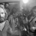 Charles Manson handcuffed being escorted to jail as the press photographs him.