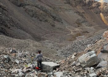 rescue personnel stands in rocky mountain landscape