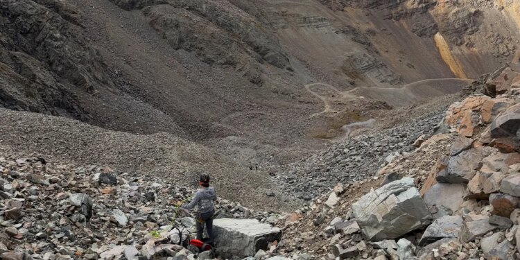 rescue personnel stands in rocky mountain landscape