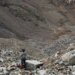 rescue personnel stands in rocky mountain landscape