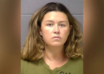 Booking mugshot of Corie A. Walsh facing forward against a gray wall wearing an olive green shirt.