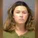 Booking mugshot of Corie A. Walsh facing forward against a gray wall wearing an olive green shirt.