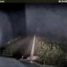 A deer lies motionless on a roadside as a deputy approaches.